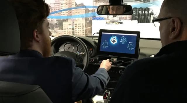 Mid-air haptics transducer array integrated into custom vehicle trim behind an acoustically transparent grille